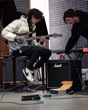 Un joven guitarrista toca la guitarra en el estudio de grabación Marshall