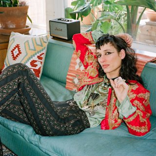 Zumi Rosow laying on a couch.