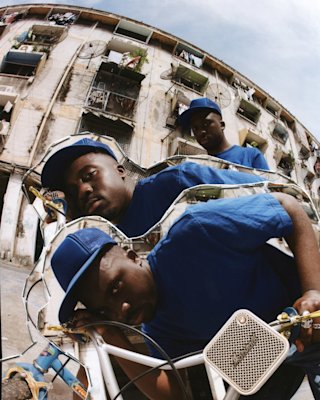 Kelvin Krash standing in front of the building and holding a Marshall Willen portable bluetooth speaker.