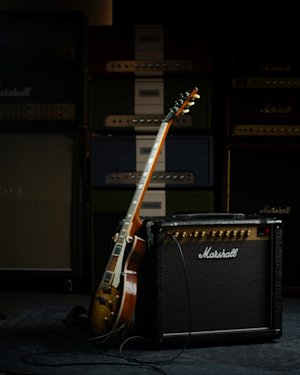 An electric guitar leaning against a Marshall DSL20 combo.