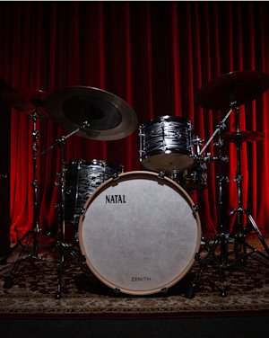 A natal drum kit placed in the center of a recording studio.