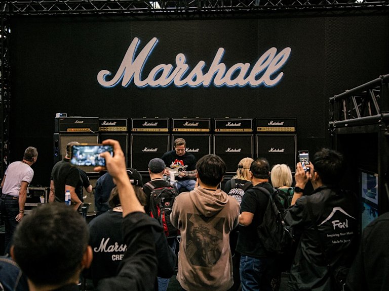 A guitar player playing at the NAMM Marshall booth