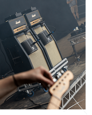 A person playing a guitar in front of two Marshall Studio Vintage Head amplifiers.