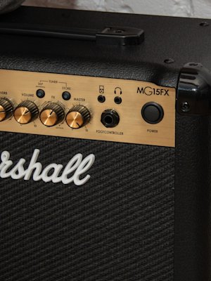 The Marshall MG15GFX Combo in front of the white brick wall.