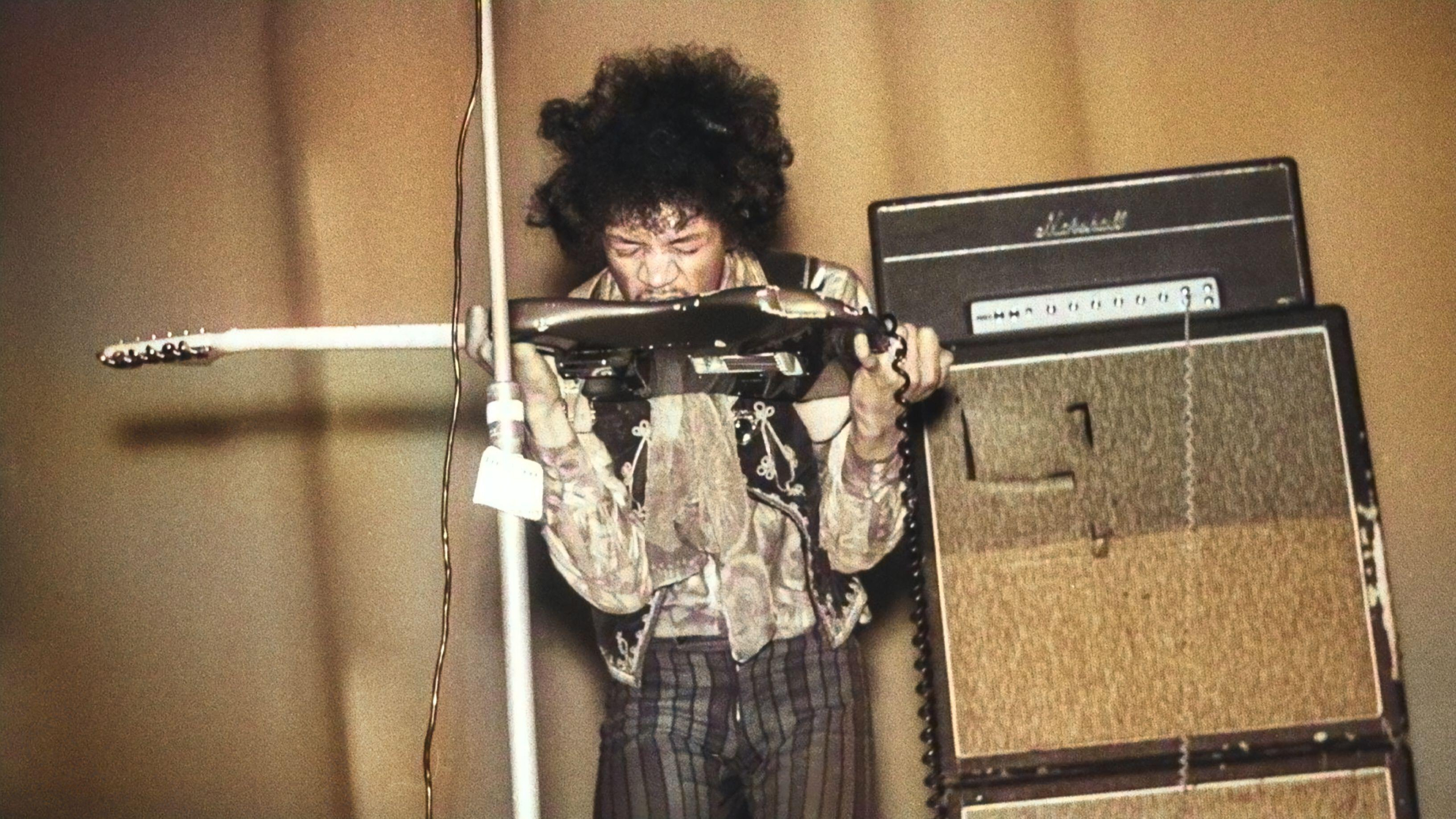 Jimi Hendrix jouant de la guitare avec sa bouche