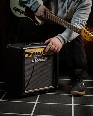 Guitarist tuning up the Marshall MG15G Combo amplifier before rehearsal.