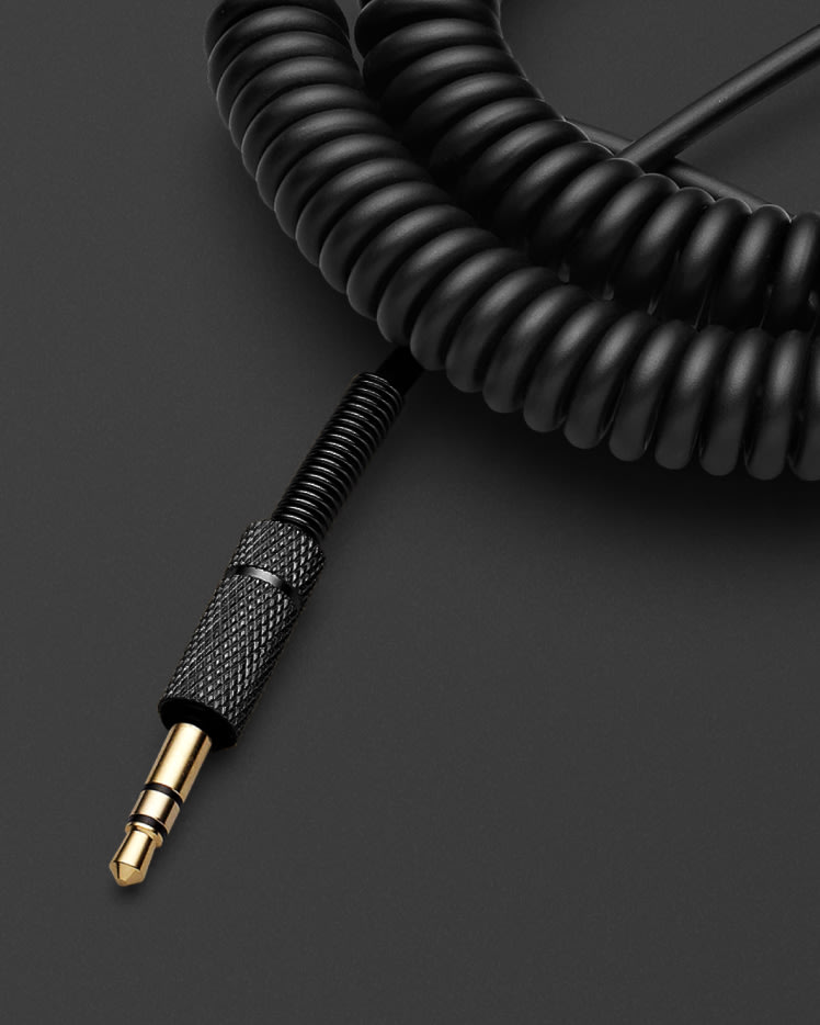 Un Cable de Audio de Altavoz Marshall Negro sobre una superficie negra.