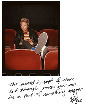 Billie Joe Armstrong sat in red cinema chairs.