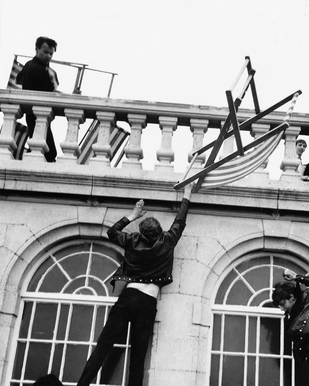 A black and white image of a man climbing the walls of a building