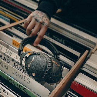 A person holding Monitor III A.N.C. over vinyls