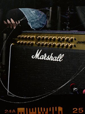 A Marshall JVM410 Combo amplifier with a woman sitting next to it.