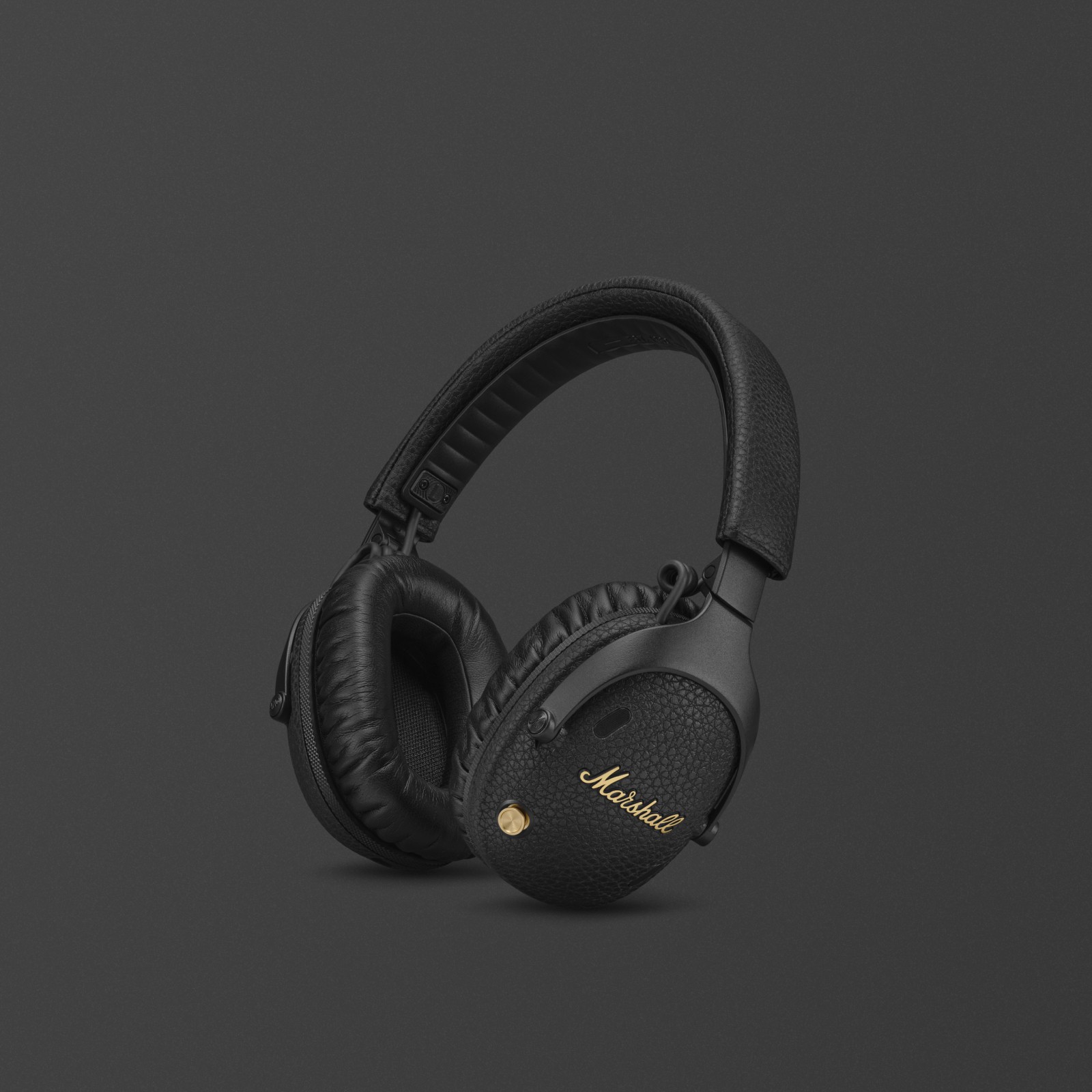 Marshall Monitor III A.N.C. Black over-ear bluetooth headphones featuring gold accents, displayed against a dark background.