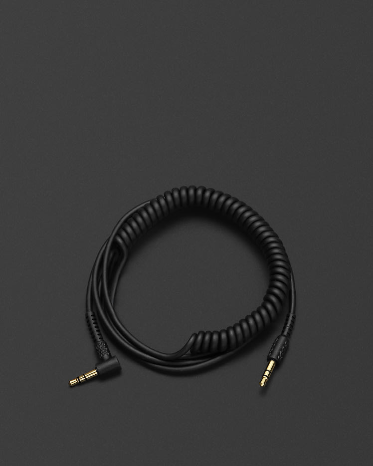 A Marshall black coiled audio cable on a black surface.