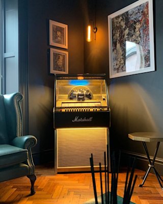The Marshall jukebox lighted and placed in the corner of a room.