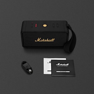 A black Marshall Middleton portable speaker with carrying strap, a USB charging cable, and user manuals are displayed on a dark surface.