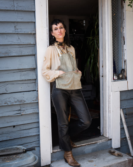 Zumi Rosow is standing in front of a door.