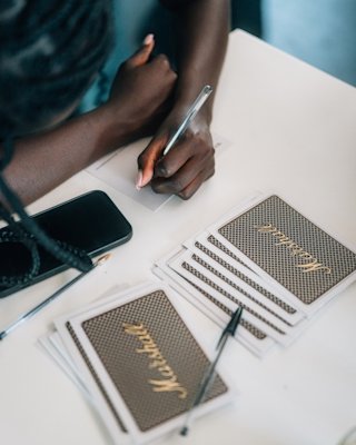 Woman signing a card with the photo of a Marshall front grid.