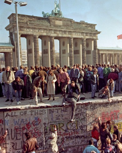 1989년 브란덴부르크 문에서 베를린 양측 시민들이 축하 행사를 하고 있습니다.