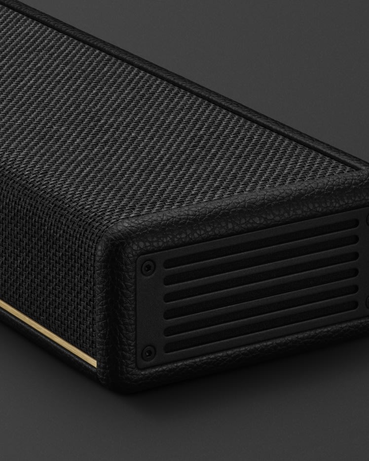 A close-up of the corner of the Marshall Heston 120 with a textured finish, perforated panel, and gold accent stripe.