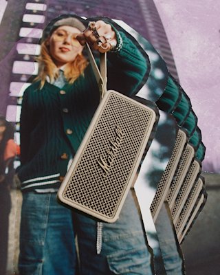 A person holds the Marshall Middleton II Cream portable Bluetooth speaker towards the camera, with a multi-exposure effect and a building visible in the background.