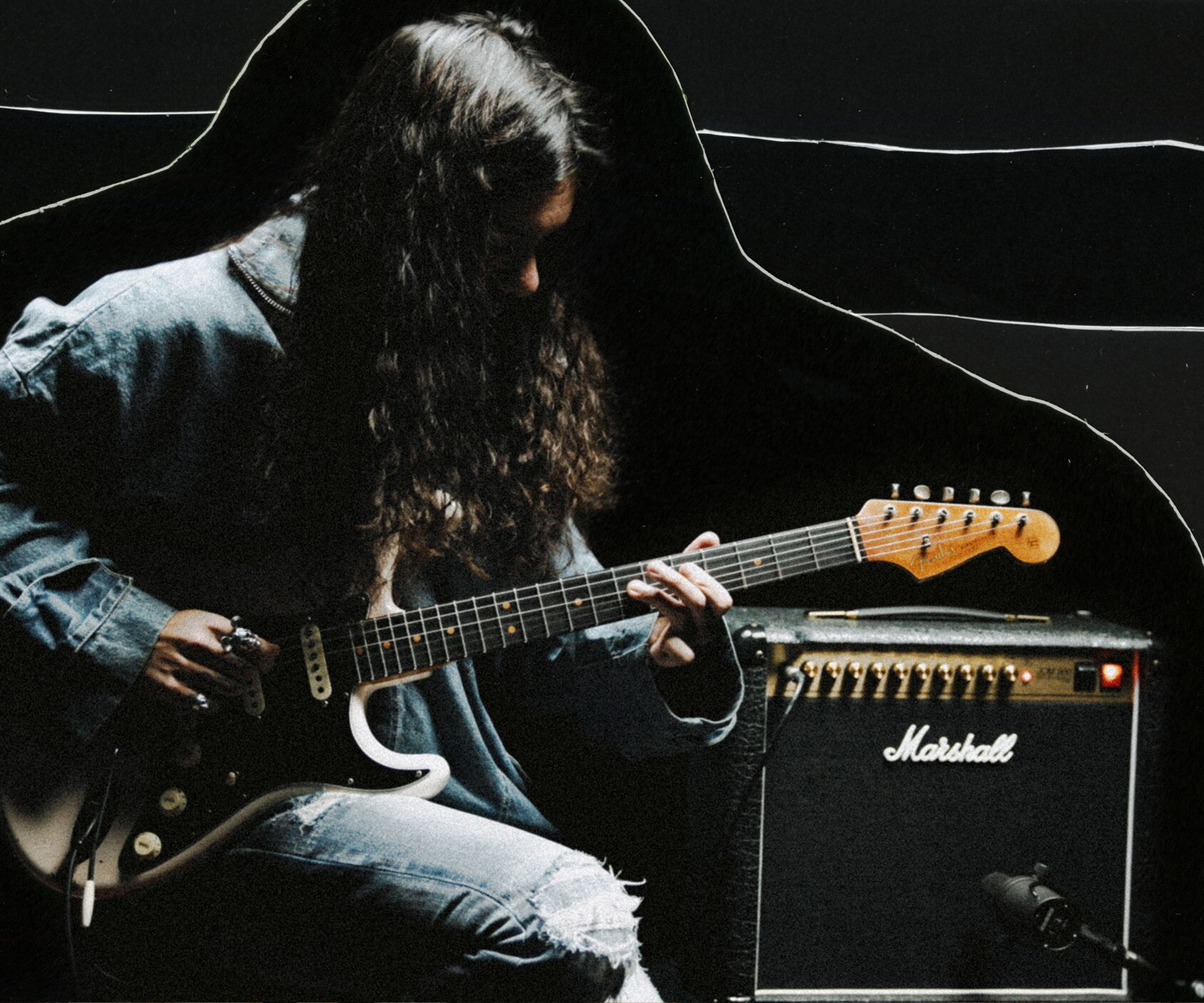 Une personne joue de la guitare sur un ampli Marshall