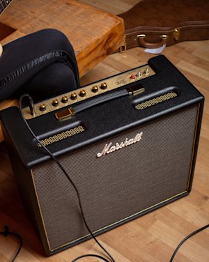 Vista superior del Marshall Origin50 Combo mostrando los detalles y el guitarrista al fondo.