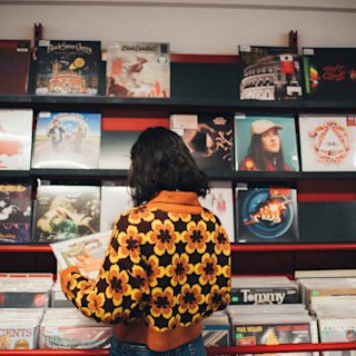 Woman wearing a flower jumper in a record store