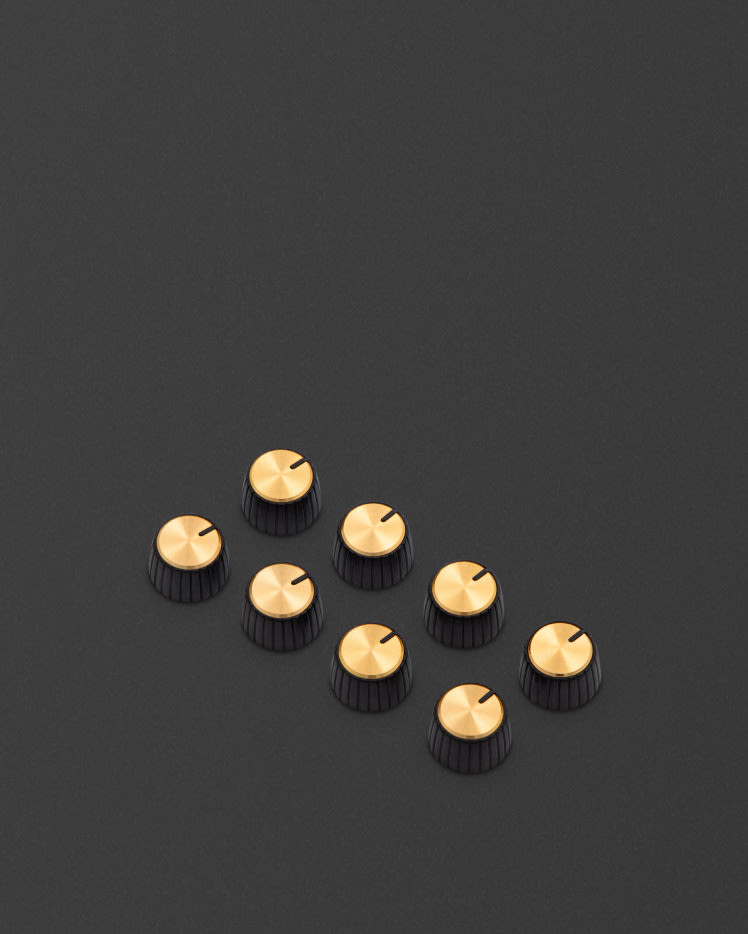 These knobs feature a black body, gold cap, and have a D-shaped push on profile.