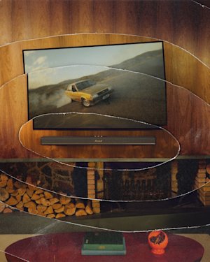 Heston 120 below the TV, and stacked firewood fills the fireplace underneath.