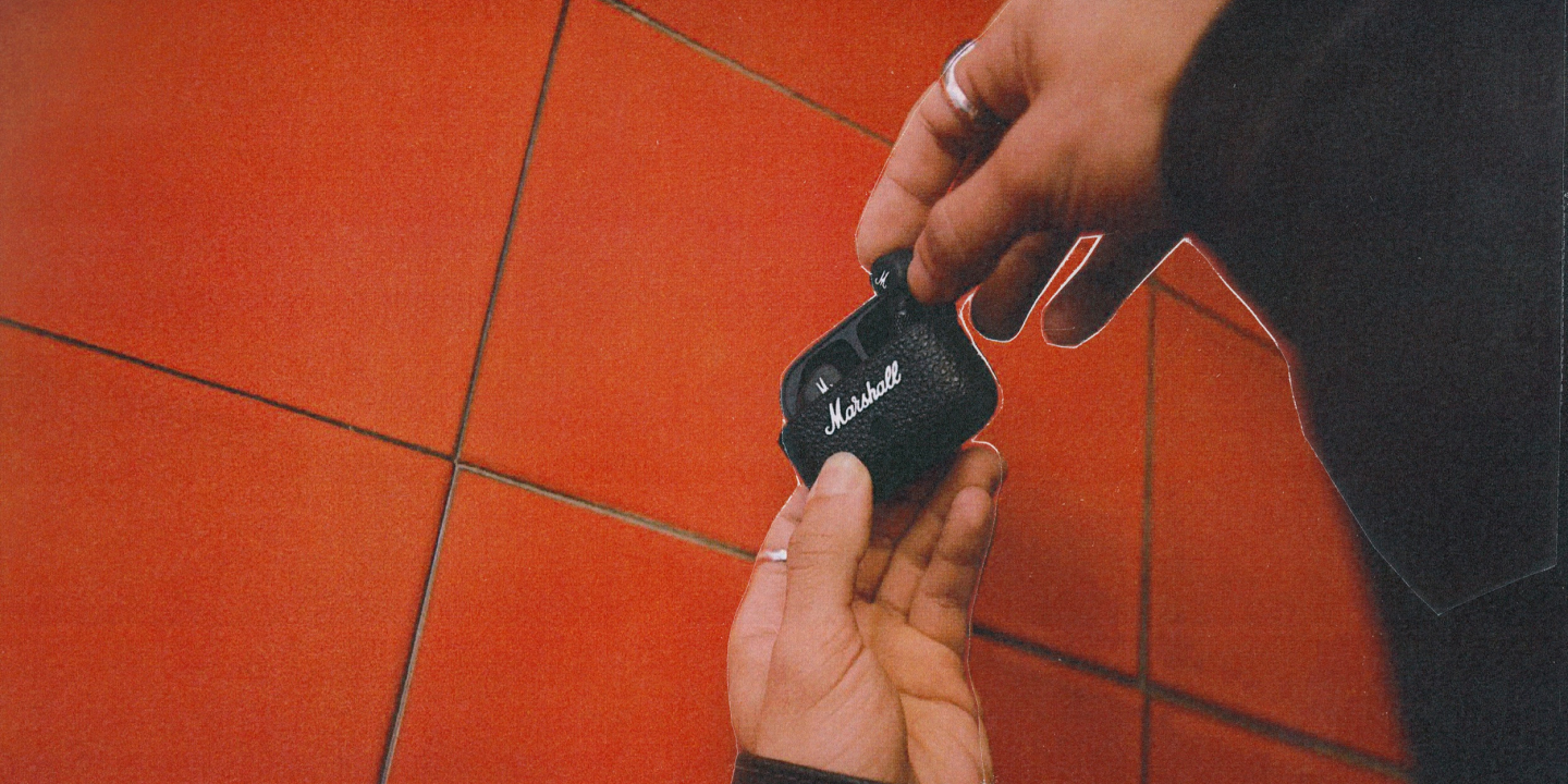 A person holding the Marshall Motif II A.N.C. earbuds.