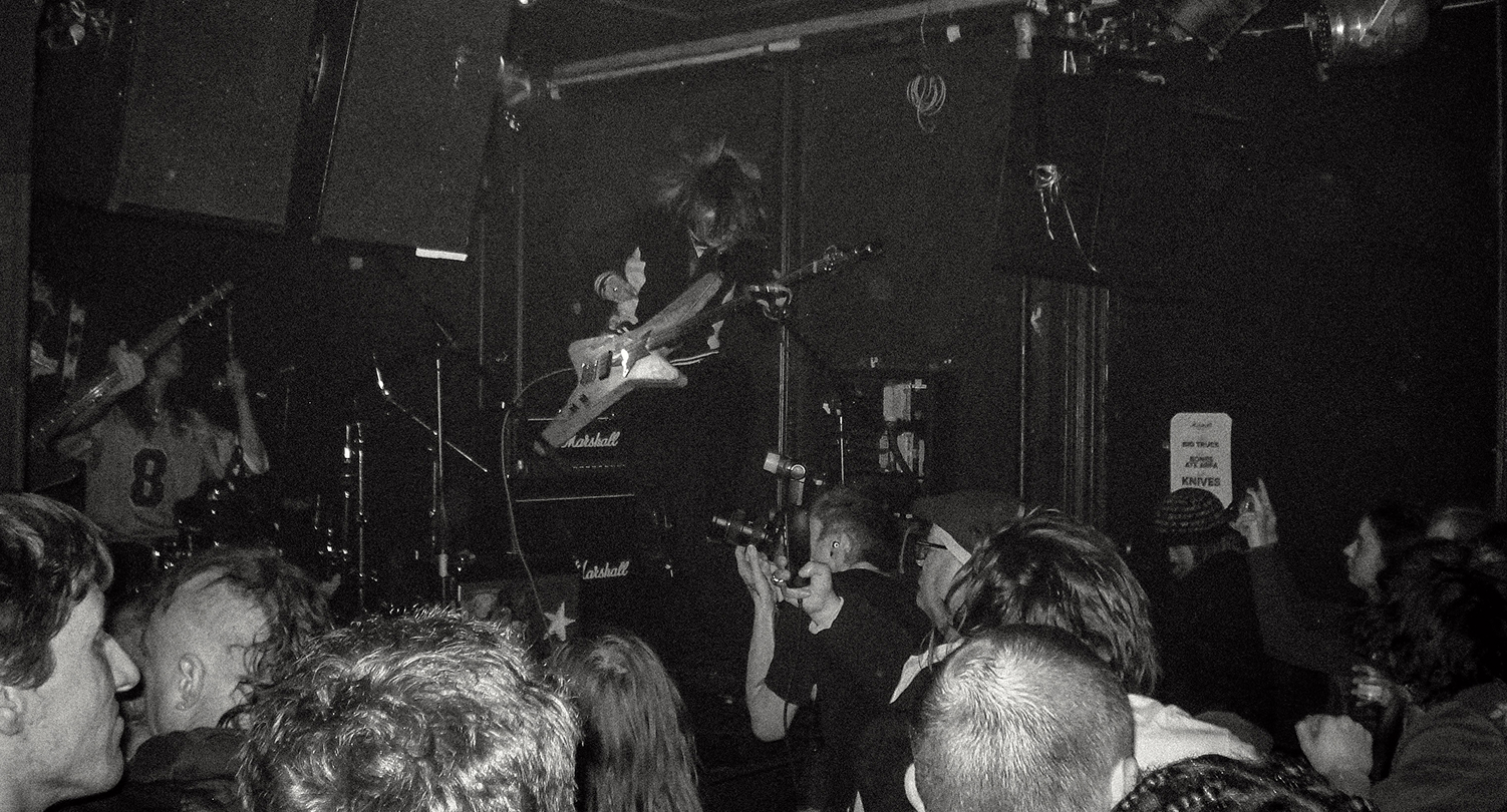 A Black and White image of a band playing during a small gig
