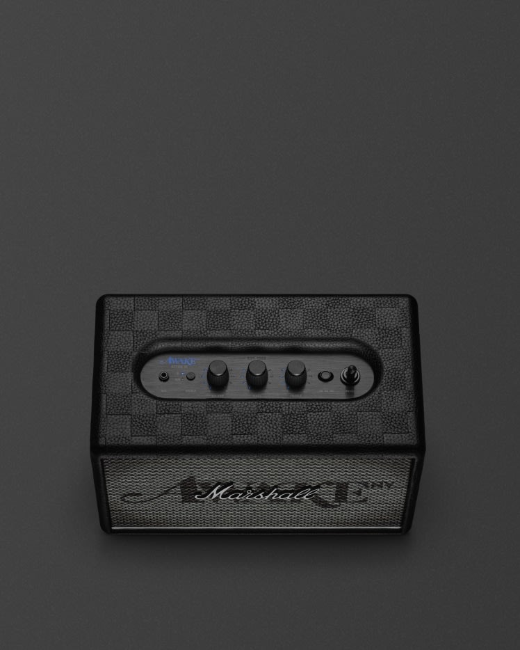 The Acton III Awake NY Edition bluetooth home speaker with three control knobs on top and the iconic "Marshall" logo on its front grille, set elegantly against a dark background.