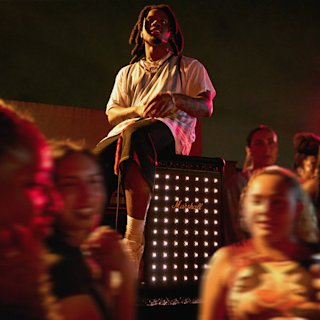 Denzel Curry seating on top of the Bromley speaker by Marshall