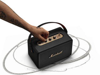 Adjusting the control knob on the Marshall Kilburn III Black and Brass portable speaker.