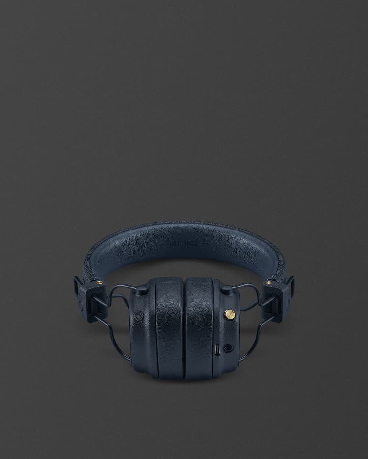 Ein Paar Marshall Major V Midnight Blue Over-Ear-Bluetooth-Kopfhörer mit gepolstertem Kopfband, dargestellt vor einem schlichten dunklen Hintergrund.