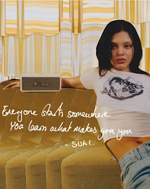 Suki was sitting on a couch next to a Marshall Emberton II Cream portable speaker.