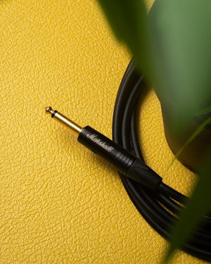 A black Marshall cable on a yellow background