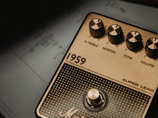 Un pedal de overdrive Marshall 1959 delante de un libro.