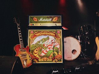 JCM900 Lunar New Year Edition 2025 Half Stack by Marshall, and a drum set stand on a stage.