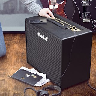 A guitarist studying and adjusting his sound on Marshall CODE50 Combo