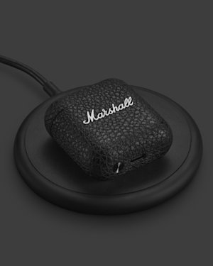 Un estuche de carga Marshall Minor IV sobre una base de carga inalámbrica.