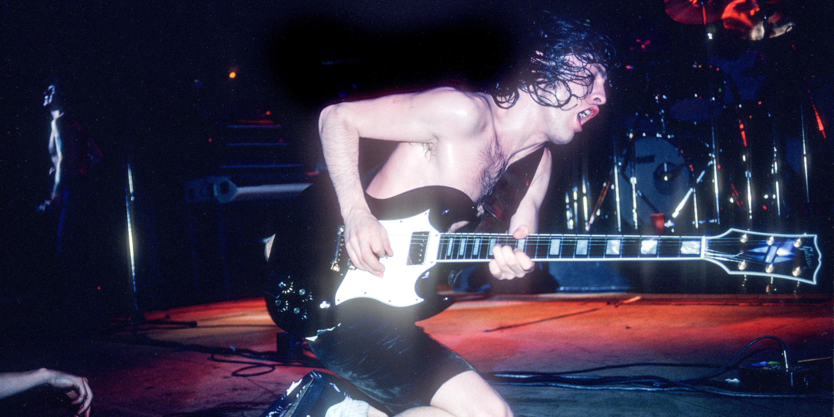 Angus Young performing at a concert. 