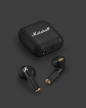 Un par de auriculares Marshall Minor IV delante de un estuche de carga Minor IV.