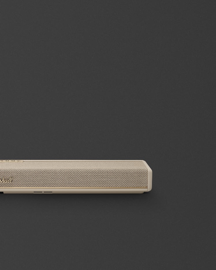 Marshall Heston 60 Cream soundbar with a textured front and gold accent, sits near the bottom left against a plain dark background.