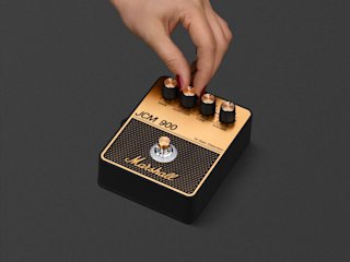 Una persona afinando el pedal Marshall JCM900 Overdrive.