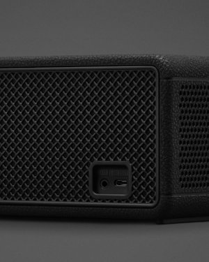 The AUX port on the backside of a black Marshall Middleton II speaker.