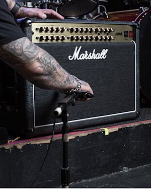 Person with tattoos placing the mic on the left side of JVM410 Combo