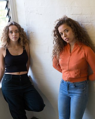 Nilufer Yanya et Elif Yanya devant le mur de briques blanches.