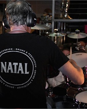 Person seen from the back playing Natal Drums