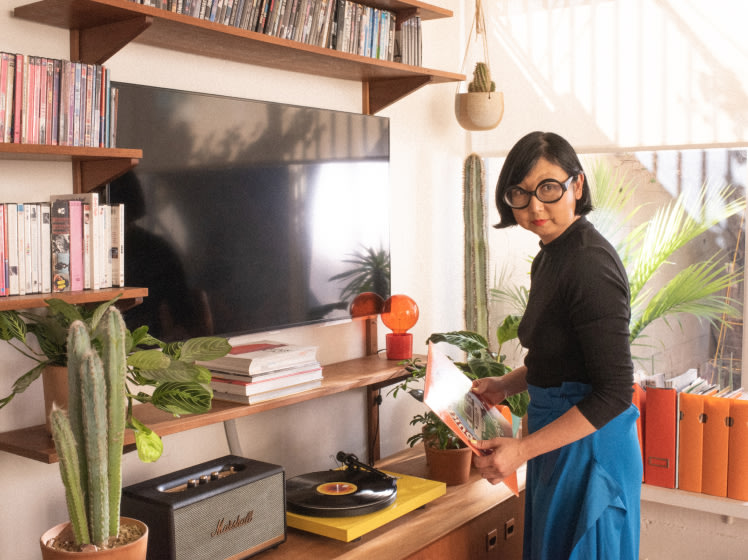 Shirley Kurata stands in a living room.